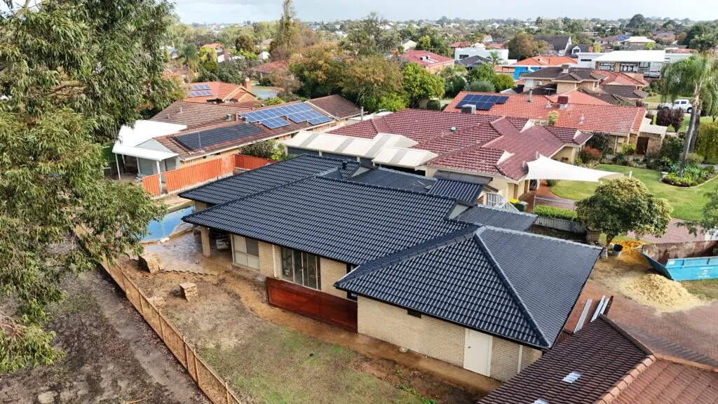 Drone view of a roof restored by Kili & Cousins standing out among weathered neighbouring roofs, Perth
